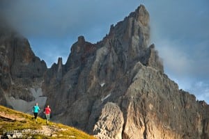 Two women trail running at sunset in the Italian Dolomites
