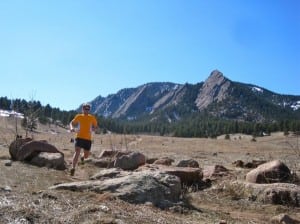 Ian Torrence running in front of the Flatirons.