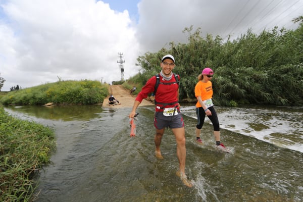Racers wade water flooding the lower sections of the trails during the Promised Land Sea to Jerusalem Race. Photo: Carin Goldblatt