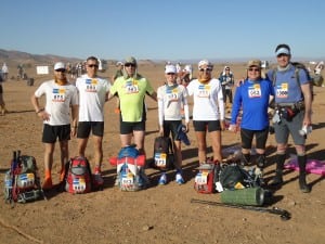 The author holding the Inov-8 RaceElite 15 and her Tent #56-mates before the start of the 2012 Marathon des Sables (Greg York photo credit).