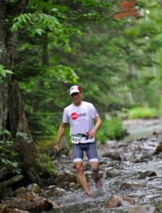 Jonathan Toker running in a stream at the Ultimate XC race.