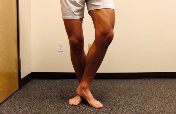 The author, performing a mid-foot self-mobilization in standing. Try with soft-heeled shoes on, if too sore with direct skin contact. midfoot mobility